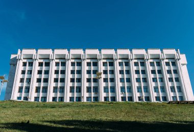 beyaz mavi gökyüzüne karşı bina. ön planda yeşil çimen
