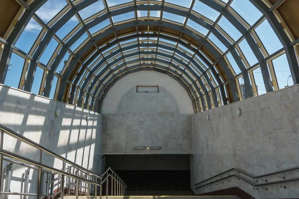 Afdaling in de metro. Een brede trap en een glazen dak in de vorm van de boog — Stockfoto