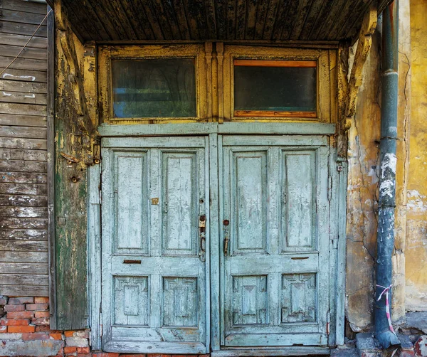 Velha porta rasgada em uma casa velha — Fotografia de Stock