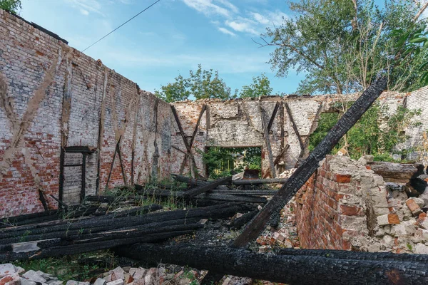 Armazém abandonado com um telhado em ruínas e troncos de madeira carbonizados em Samara — Fotografia de Stock