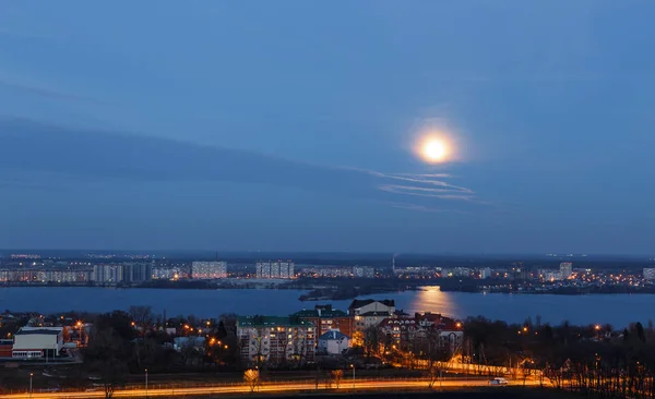 Vista de la luna temprana en el cielo azul de la noche con reflejo en el río. Contexto — Foto de Stock