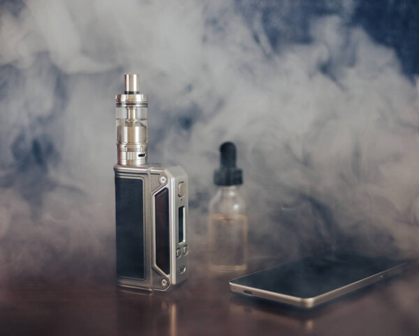 Аппараты Vape, E-сигарета для выпаривания, жидкость в бутылке и мобильный телефон
 