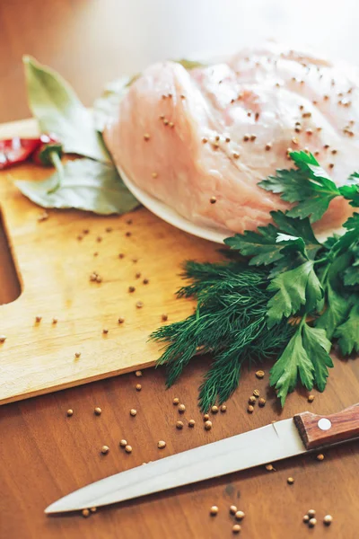 Carne cruda en tabla de cortar con verduras verdes, pimiento rojo, hoja de laurel, especias, cuchillo — Foto de Stock