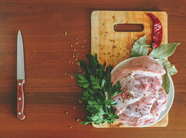 Carne cruda en tabla de cortar con verduras verdes, pimiento rojo, hoja de laurel, especias — Foto de Stock
