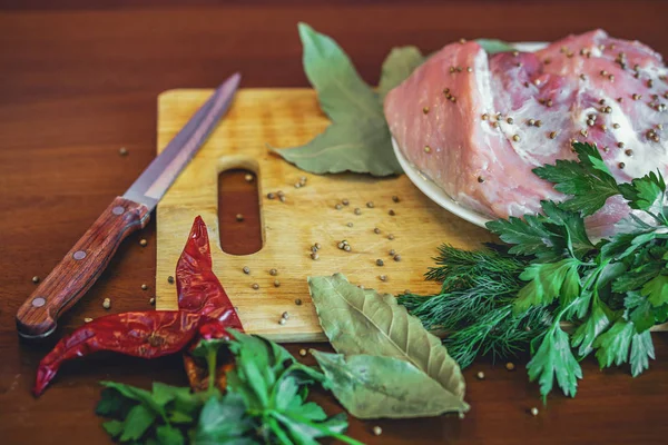 Carne cruda en tabla de cortar con verduras verdes, pimiento rojo, hoja de laurel — Foto de Stock