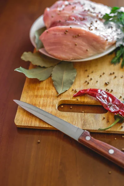 Carne cruda en tabla de cortar con, pimiento rojo, hoja de laurel, especias y cuchillo — Foto de Stock