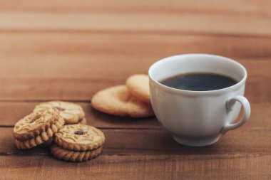 Bir fincan sıcak kahve ve kurabiye ahşap arka plan üzerinde. kopya alanı metin için