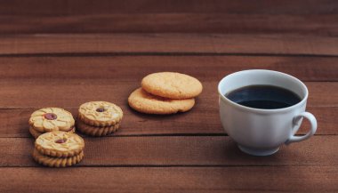 Bir fincan sıcak kahve ve kurabiye ahşap arka plan üzerinde. kopya alanı metin için