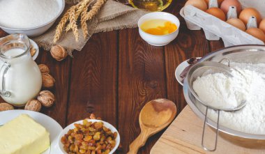 Ahşap bir arka plan üzerinde pişirme için malzemeler. yumurta, un, süt, tereyağı, şeker 