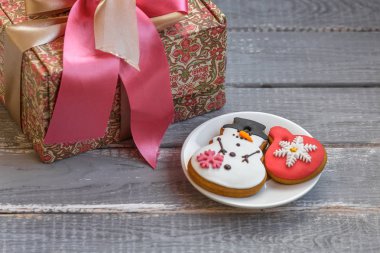 El yapımı hediye kutusu ve bir plaka üzerinde ahşap rustik masa üzerinde ev yapımı gingerbreads. 