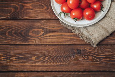 Bir plaka üzerinde taze olgun domates. Üstten Görünüm. Rustik ahşap arka plan ile boşaltmak