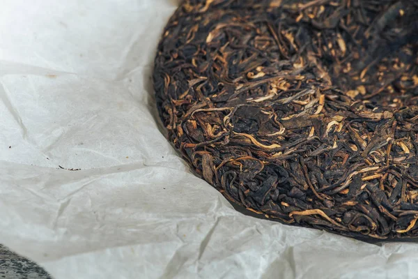 Eski Shen puerh Çin fermente çay papirüs kağıdı arka plan makro yakın çekim üzerinde — Stok fotoğraf