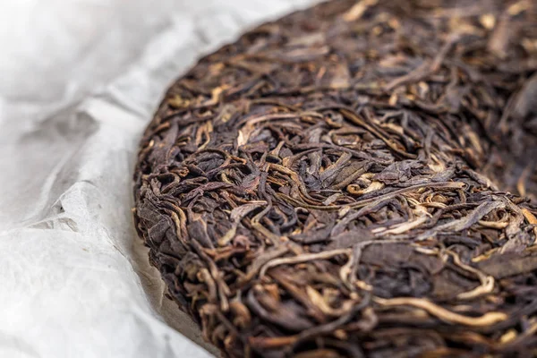 Eski Shen puerh Çin fermente çay papirüs kağıdı arka plan üzerinde — Stok fotoğraf
