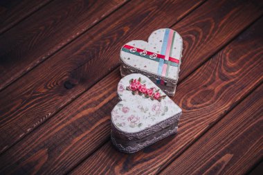 Karanlık rustik ahşap arka plan üzerinde kalp şeklinde iki el yapımı Hediyelik bıçaklar. 