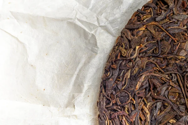 Eski Shen puerh Çin fermente çay boşaltmak papirüs kağıdı zemin üzerine. — Stok fotoğraf