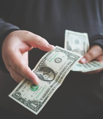 Para bir bize Doları banknot ve holding nakit elinde veren adam. Para kredi 