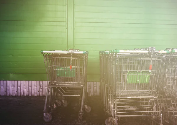 Nákupní vozíky v supermarketu na zeleném pozadí — Stock fotografie