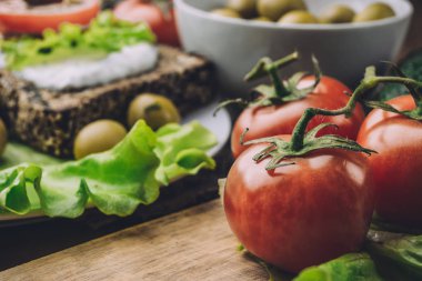 Ahşap masa ve sos ile ekmek, zeytin kase mutfak üzerinde kırmızı domates 