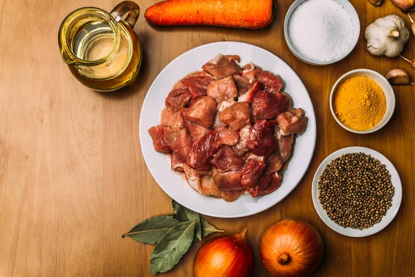 Vista superior de los ingredientes de la cocina en la mesa de madera rústica. Carne cruda, cebolla, zanahoria — Foto de Stock