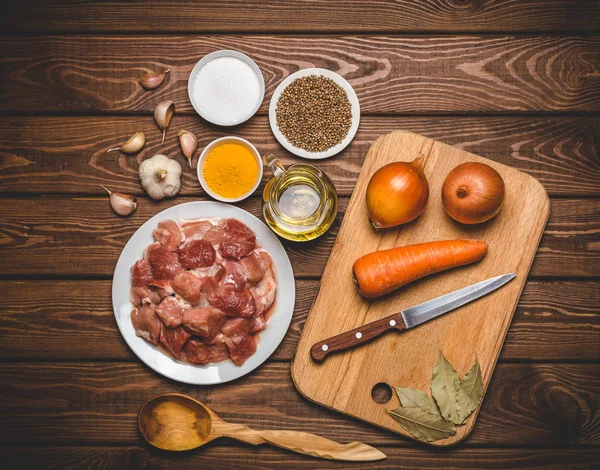 Ingredientes de cocina: carne cruda en rodajas, aceite, especias, ajo, zanahoria, cebolla , — Foto de Stock