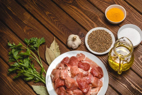 Ingredientes de cocina: carne cruda en rodajas, aceite, especias, ajo, laurel y perejil — Foto de Stock