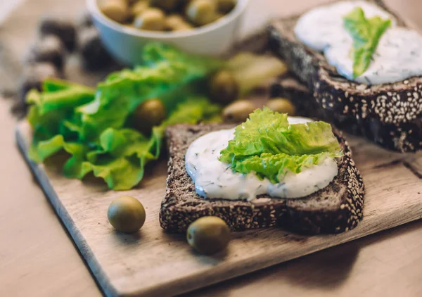 Sandwiches of homemade bread with cheese sauce or cream, lettuce, walnuts, olive