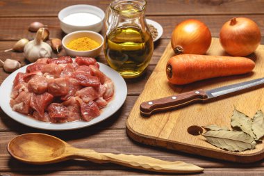 Pişirme malzemeleri. Kesme tahtası. Dilimlenmiş çiğ et, pirinç, yağ, baharat, sarımsak, 