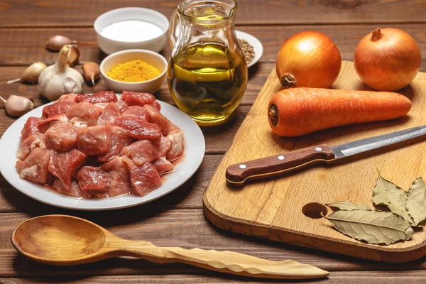 Cocinar ingredientes. Tabla de cortar. Carne cruda en rodajas, arroz, aceite, especias, ajo , — Foto de Stock