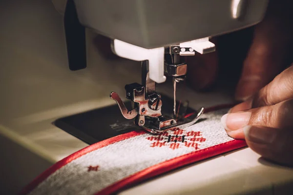 Máquina de costura e as mãos das mulheres que trabalham com ele, imagem de perto tonificada — Fotografia de Stock