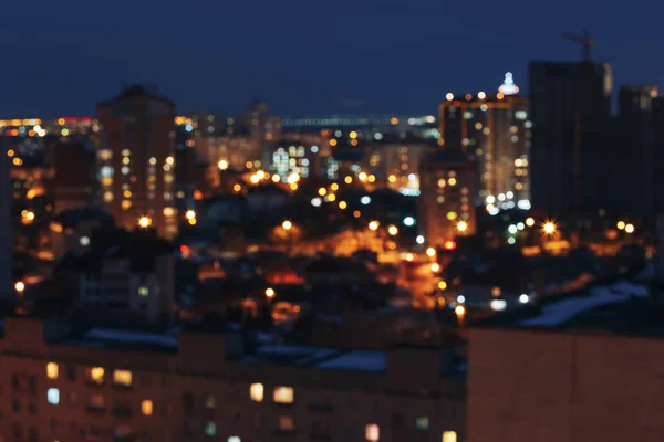 Vista bokeh de las luces nocturnas de la ciudad, casas, fondo de paisaje urbano moderno borroso — Foto de Stock