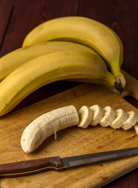 Разрезать на ломтики банан на деревянной доске, вертикальное изображение — стоковое фото