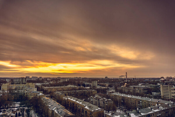 Aerial evening cityscape from rooftop of Voronezh. Houses, sunset, sky, clouds, dramatic view in warm tones