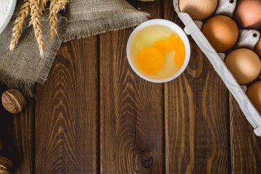 Üzerinde koyu renkli rustik ahşap ev yapımı hamur işleri için malzemeler pişirme Üstten Görünüm