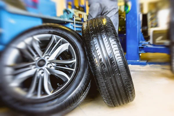 Wheels in a car repair shop, in background of of blurred garage interior — Stock Photo, Image