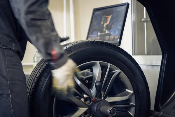 Механічний працівник робить балансування комп'ютерного колеса на верстаті спеціального обладнання — стокове фото