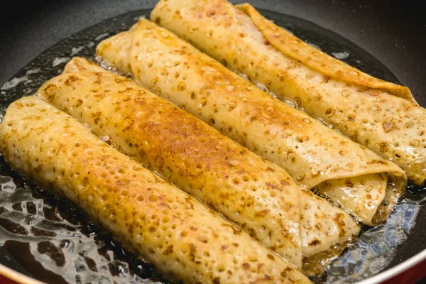 Les crêpes sont frites dans une poêle à frire à l'huile chaude, Produits semi-finis, Nocif — Photo