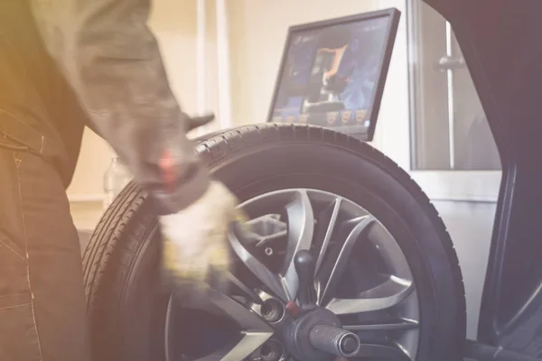 Механічний працівник робить балансування комп'ютерного колеса на інструменті спеціального обладнання — стокове фото