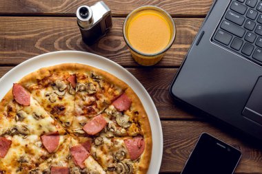 Pizza jambon ve mantar plaka, dizüstü bilgisayar, elektronik sigara, cep 