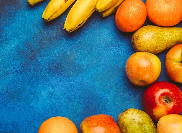 Вид сверху сочных фруктов на синем фоне в рамке — стоковое фото