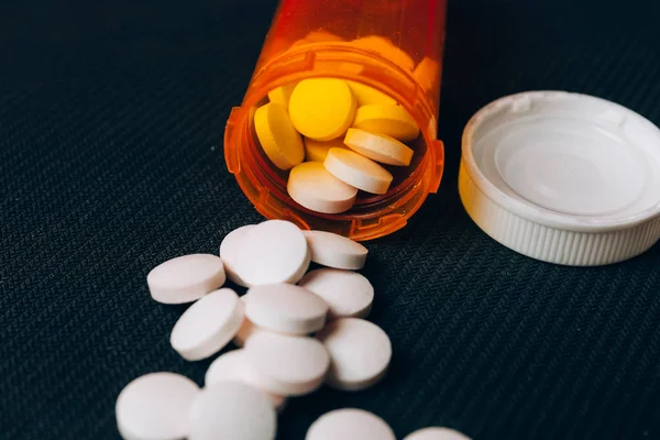 Ιατρική χάπια ή δισκία χυθεί από ένα μπουκάλι χάπι στο τραπέζι — Φωτογραφία Αρχείου