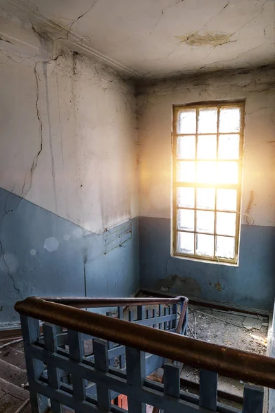 Gran ventana luminosa y escaleras en viejo edificio abandonado sucio —  Fotos de Stock