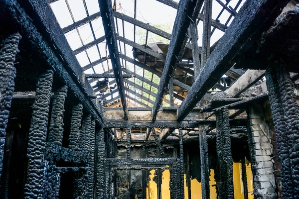 Verbrannte Innenräume des Hauses nach Brand. Verkohlte Decken und Stützen. — Stockfoto