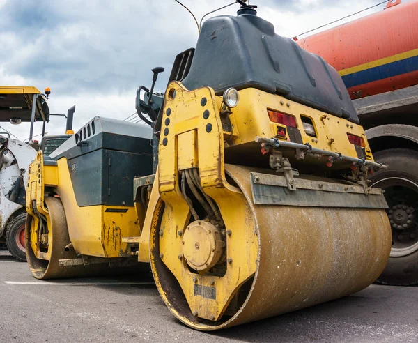 Yellow construction tractor road roller and technique for lay asphalt Stok Gambar Bebas Royalti