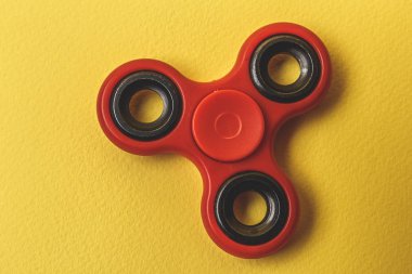 Sarı kağıt arka plan üzerinde kırmızı kıpır Spinner