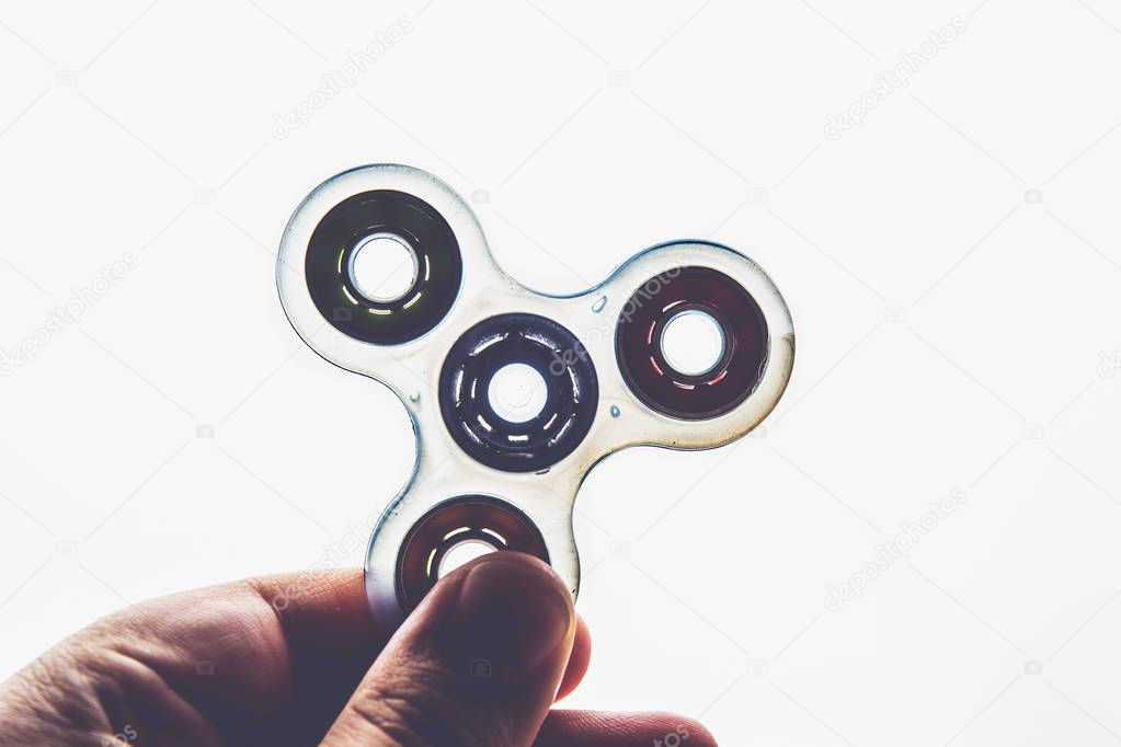 Man playing with a transparent hand Fidget Spinner toy