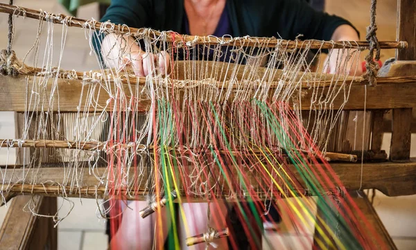 Craftsperson Woman working behind an old wooden loom