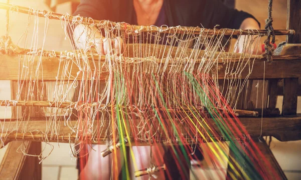 Eski ahşap dokuma tezgâhı çalışan kadın