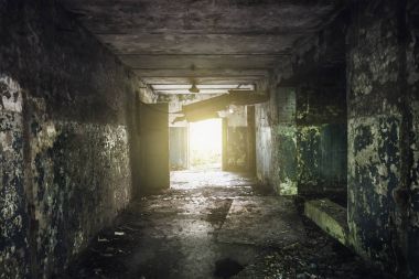 Terk edilmiş bir binada duvarlarda soyulması boya ile karanlık koridor