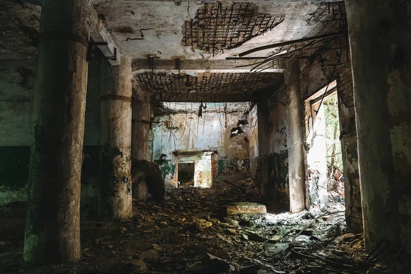 Donkere zaal van verwoeste verlaten fabriek met kolommen — Stockfoto