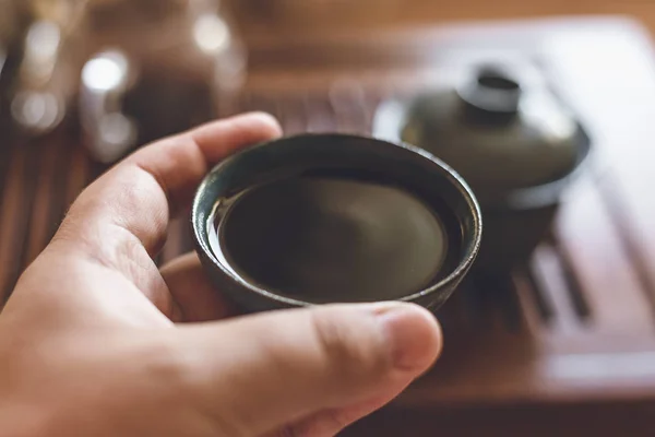 Mão masculina segura xícara ou piala ou tigela de chá preto chinês, cerimônia de chá chinês — Fotografia de Stock